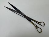 a pair of scissors on a table with a white background