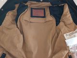 a jacket that is sitting on the floor next to a bag