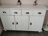 a white cabinet in the corner of a bathroom