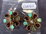 une paire de boucles d'oreilles ornées de pierres vertes et rouges