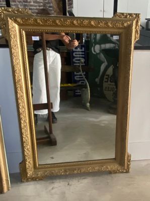 une personne en train de prendre une photo d'un miroir dans une pièce