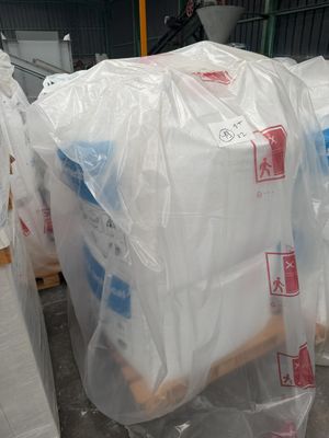 une pile de sacs en plastique posée sur des palettes dans un entrepôt