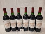 six bottles of wine are lined up on a table