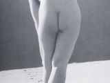 black and white photograph of a naked woman standing on a beach