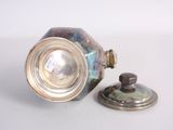 a silver vase with a lid sitting on a table