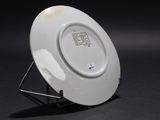 a white plate on a stand on a black background