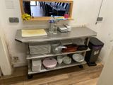 une cuisine équipée d'un évier et d'un miroir accroché au mur