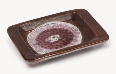 a brown and white plate with a flower design on it