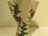 a white vase with a floral design on it on a table