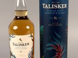 une bouteille de whisky single malt Talisker posée à côté d'une boîte en carton