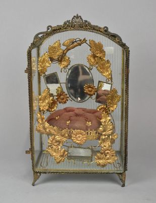 a small glass clock with a gold decoration on it