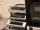 un four grille-pain posé sur une table, à côté d'autres fours
