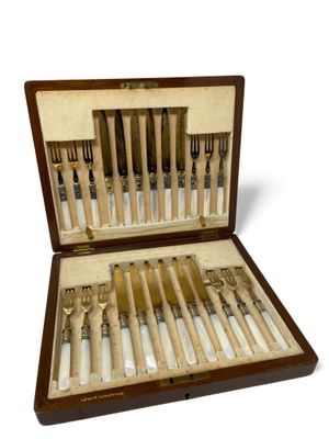 a wooden case with a set of knives and forks in it
