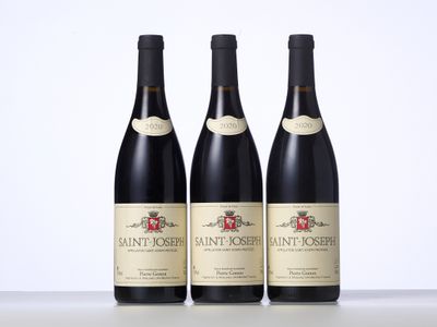 trois bouteilles de vin sont alignées sur une table