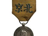 une vieille médaille sur laquelle figure une inscription en chinois au recto