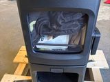 un poêle noir posé sur une palette dans un entrepôt