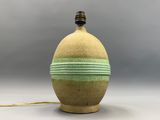 une image représentant un vase vert sur lequel est posée une lampe
