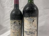 two bottles of wine sitting next to each other on a white surface