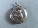 une image représentant une médaille d'argent sur laquelle figure une femme tenant un enfant dans ses bras