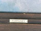 a wooden bench with a sign on it that says fortuney