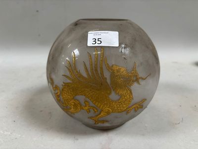 un vase en verre orné d'un dragon doré