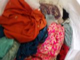 a white bag full of clothes and a cat sleeping in it