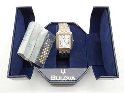 une photo d'une montre et d'un bracelet dans un coffret bleu
