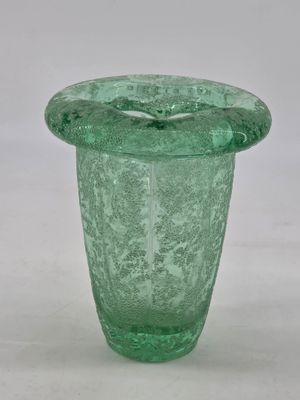 a green glass vase that is sitting on a table