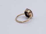 a close up of a gold ring with a brown stone