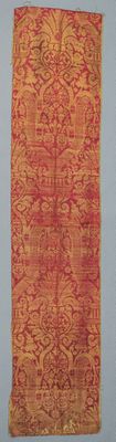 an orange and red rug hanging on a wall next to a white wall