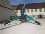 a blue crane that is sitting in the middle of a parking lot