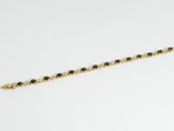 un bracelet en perles dorées et noires sur un fond blanc