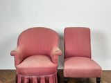 pair of pink upholstered chairs with ruffled skirt