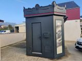 une petite cabine téléphonique noire au milieu d'un parking