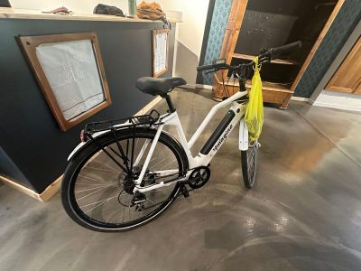 un vélo blanc avec un sac jaune à l'arrière