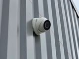 une caméra installée sur le côté d'un immeuble, avec le ciel en arrière-plan