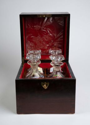 deux carafes en verre dans un coffret en bois, posées sur une surface blanche