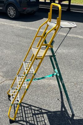 a yellow ladder that is sitting in the middle of a parking lot