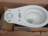 a white toilet in a box with the lid open