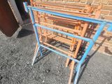 a blue and orange metal rack sitting in front of a brick wall