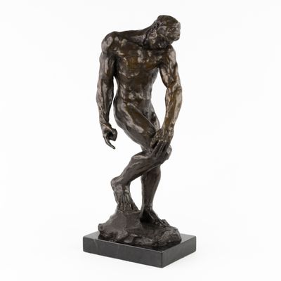 une statue en bronze représentant un homme debout sur un socle en marbre