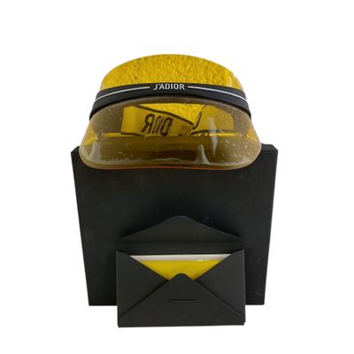 un chapeau jaune posé sur une boîte noire