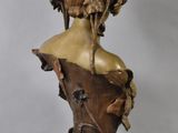 bronze bust of a woman in a dress with a bird on her head