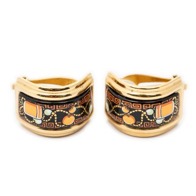 two gold rings with black and orange designs on them
