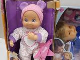 two dolls that are in a box on the table