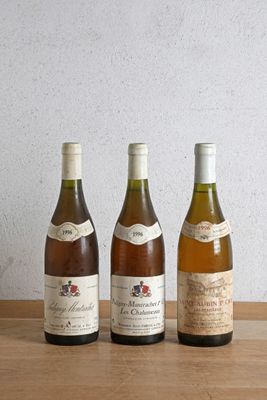 trois bouteilles de vin sont alignées sur une table en bois