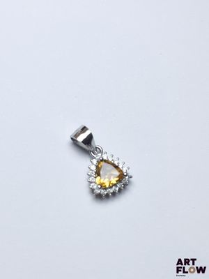 une image représentant un pendentif en forme de diamant jaune et blanc sur fond blanc