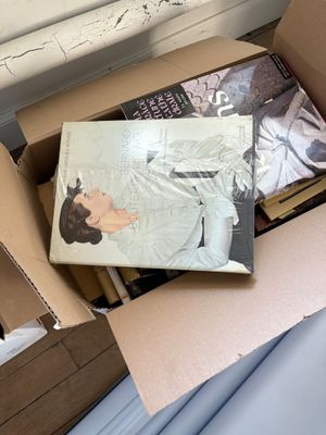 une boîte remplie de livres posée sur un lit