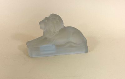 une statue de lion blanc posée sur une surface blanche