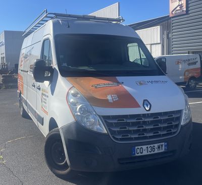 an orange and white van parked in a parking lot next to a building